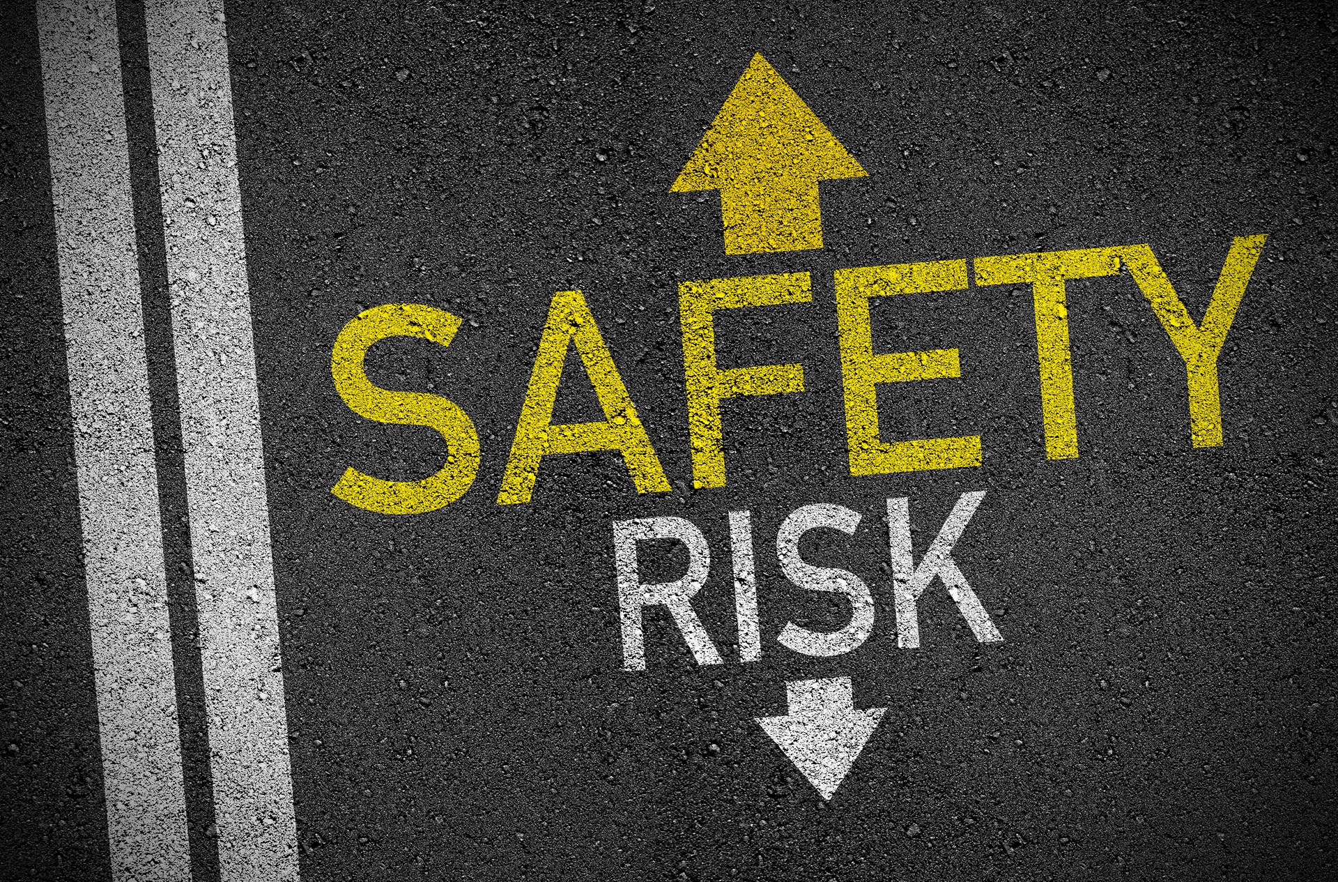 Schriftzug Safety und Risk auf Asphalt als Symbol für Entscheidungen | Dainese